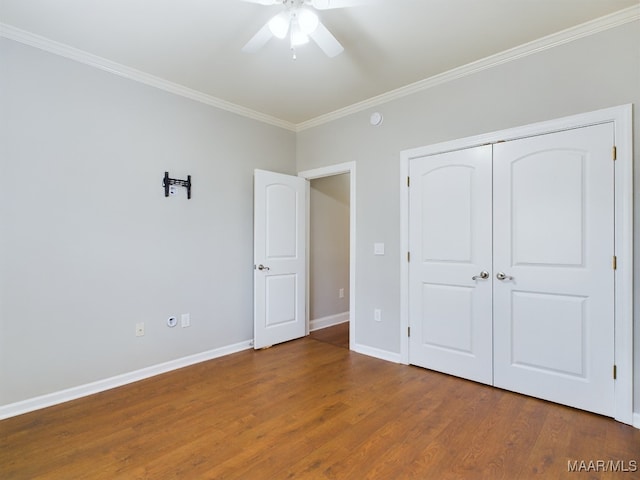 unfurnished bedroom featuring hardwood / wood-style flooring, ceiling fan, crown molding, and a closet