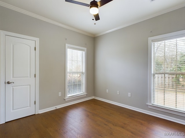 spare room featuring dark wood-type flooring, ceiling fan, and ornamental molding