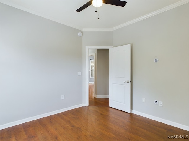 unfurnished room featuring dark wood-type flooring, ornamental molding, and ceiling fan