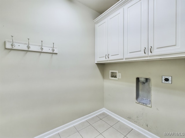 clothes washing area with cabinets, light tile patterned flooring, hookup for a washing machine, and hookup for an electric dryer