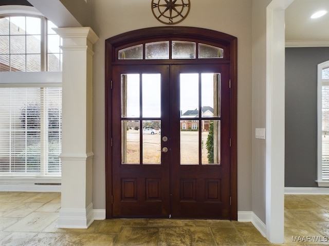 entryway featuring crown molding, decorative columns, and french doors