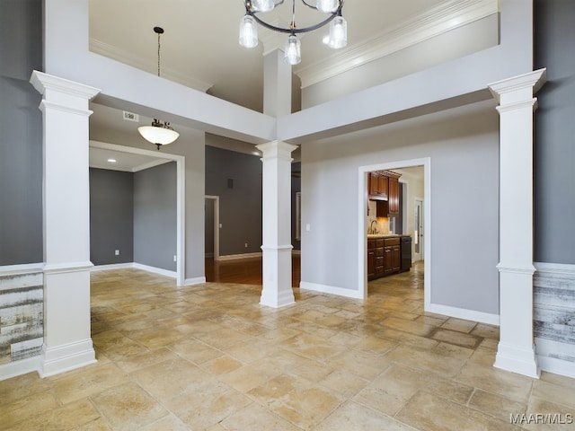 unfurnished room featuring ornate columns, crown molding, and a towering ceiling