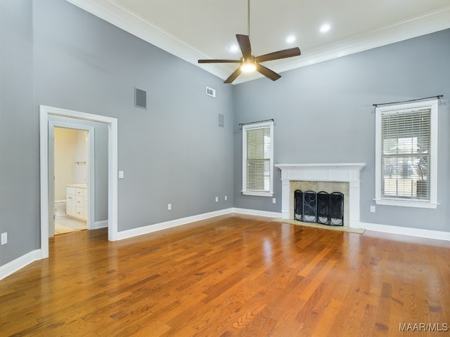 unfurnished living room with a healthy amount of sunlight, a fireplace, and wood-type flooring