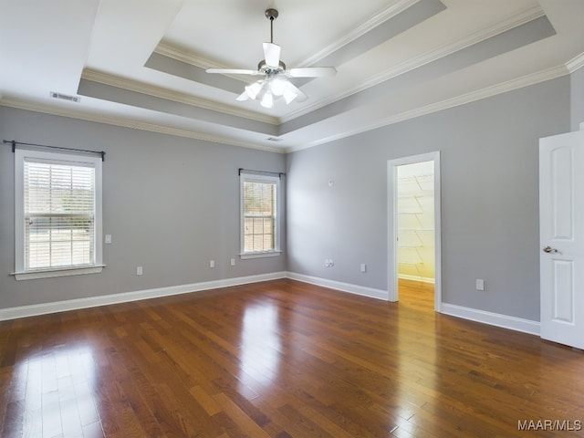 spare room featuring crown molding, dark wood-type flooring, ceiling fan, and a tray ceiling