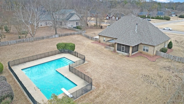 view of pool with a diving board, a patio area, and a sunroom