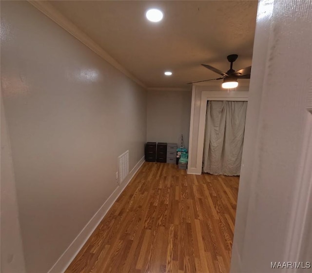 corridor featuring crown molding and light hardwood / wood-style flooring