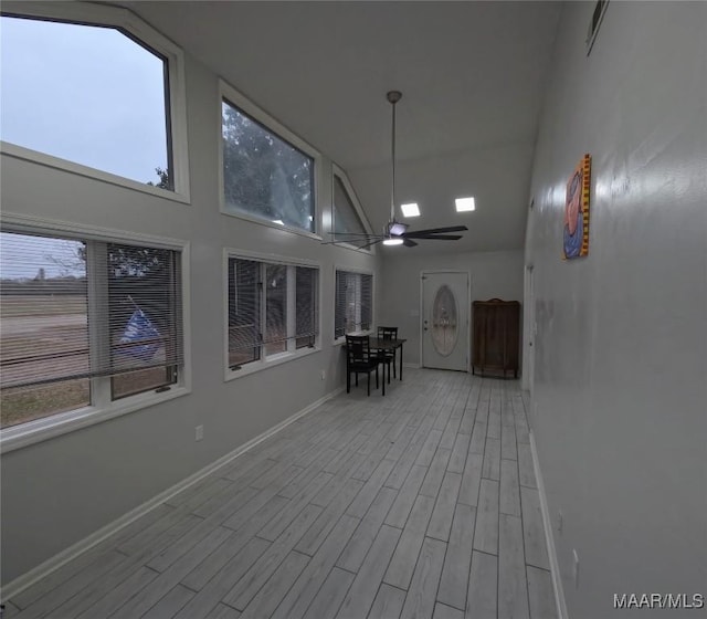 unfurnished sunroom featuring ceiling fan and vaulted ceiling