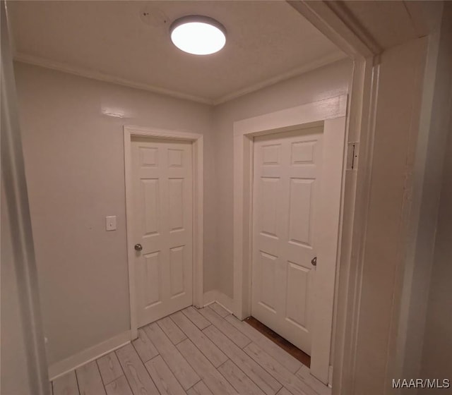 corridor featuring crown molding and light hardwood / wood-style flooring