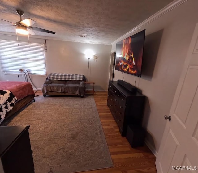 bedroom featuring crown molding, hardwood / wood-style floors, ceiling fan, and a textured ceiling