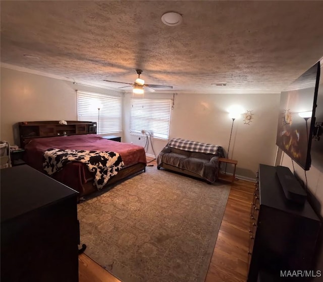 bedroom featuring hardwood / wood-style flooring, crown molding, a textured ceiling, and ceiling fan