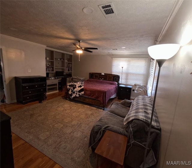 bedroom featuring crown molding, hardwood / wood-style floors, ceiling fan, and a textured ceiling