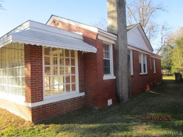 view of side of home featuring a lawn