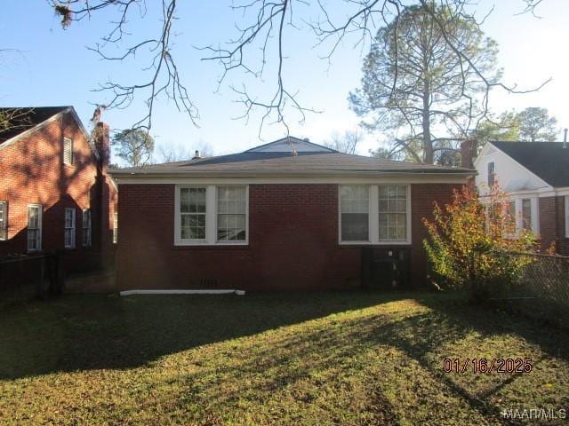 view of side of home with a lawn