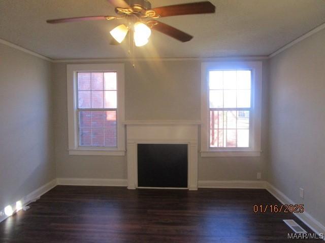 unfurnished living room featuring dark wood-type flooring and ornamental molding