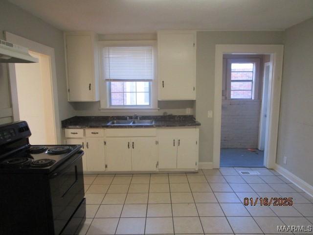 kitchen with extractor fan, white cabinets, sink, electric range, and light tile patterned flooring