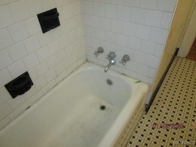 bathroom with tile patterned floors and a bathing tub