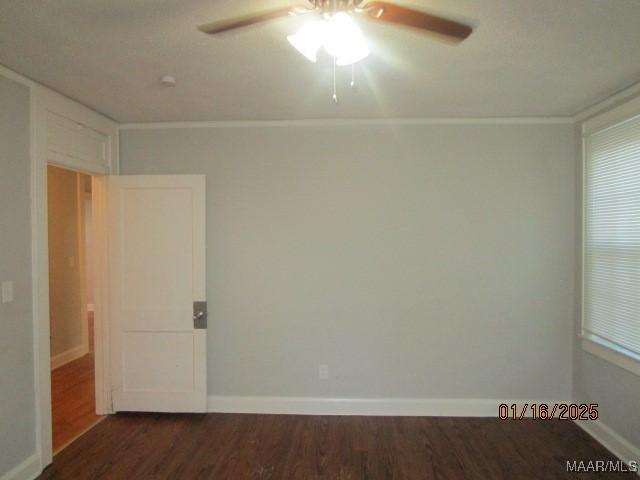 empty room featuring ceiling fan, dark hardwood / wood-style floors, and crown molding