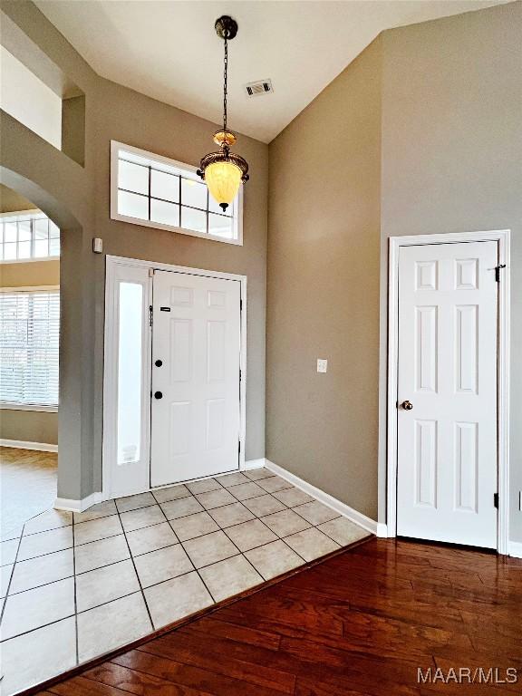 tiled foyer with a towering ceiling