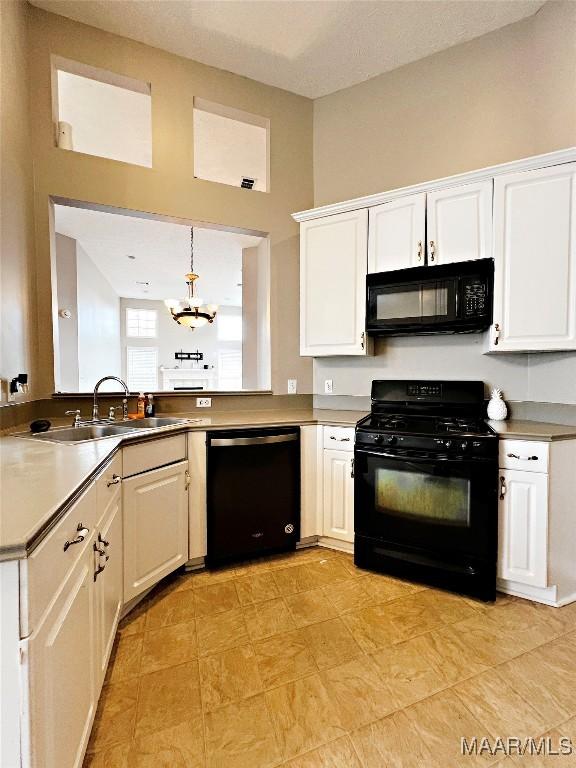 kitchen with black appliances, a chandelier, hanging light fixtures, white cabinets, and sink