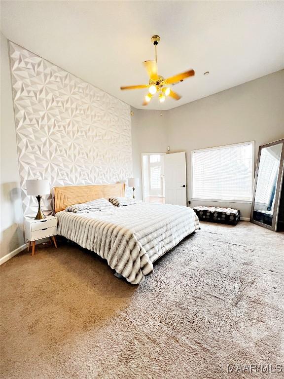 carpeted bedroom featuring multiple windows and ceiling fan