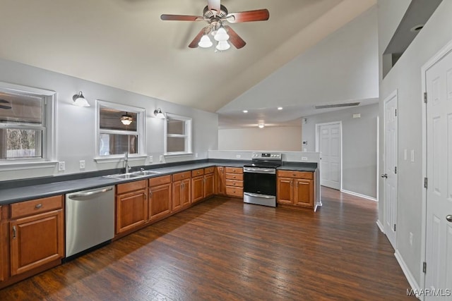 kitchen with appliances with stainless steel finishes, lofted ceiling, sink, dark hardwood / wood-style floors, and kitchen peninsula