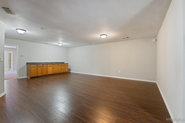 unfurnished room with dark wood-type flooring