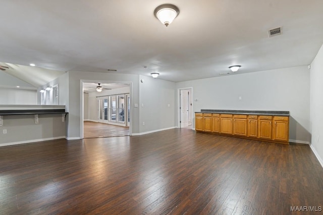 unfurnished living room featuring dark hardwood / wood-style floors and vaulted ceiling