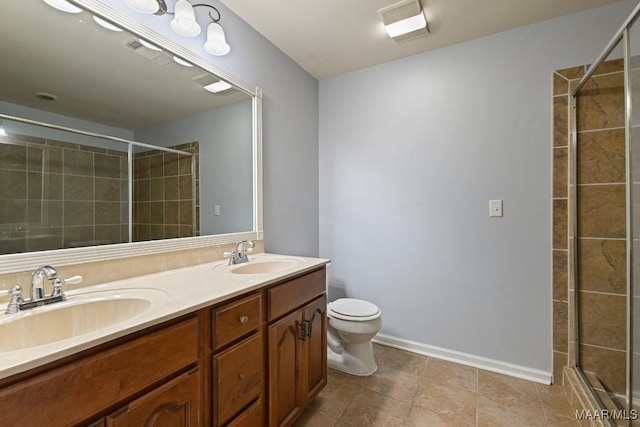 bathroom with vanity, toilet, tile patterned floors, and a shower with shower door