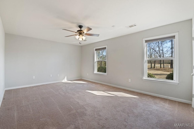 empty room featuring carpet floors, plenty of natural light, and ceiling fan