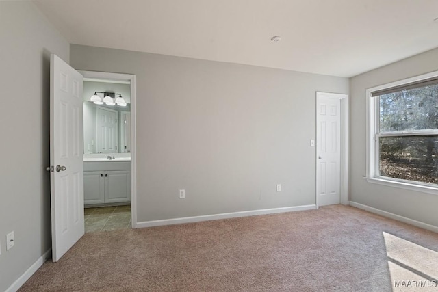 unfurnished bedroom featuring light colored carpet and sink