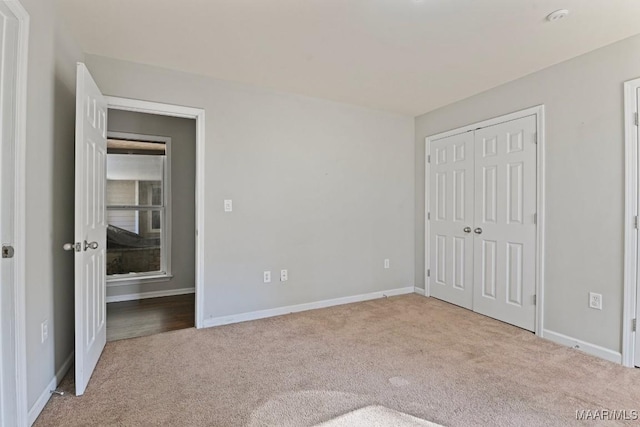 unfurnished bedroom featuring a closet and light colored carpet