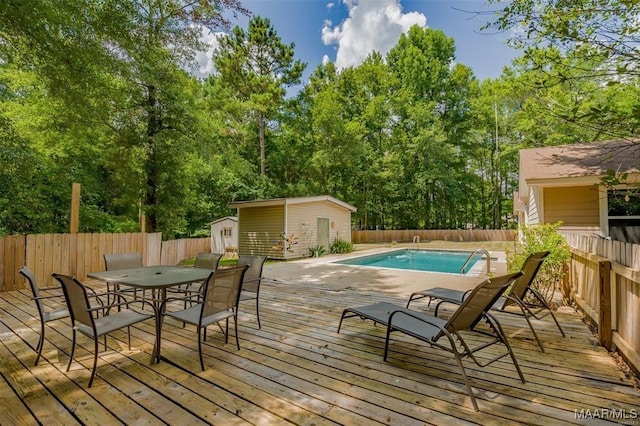 view of pool with a storage shed and a deck