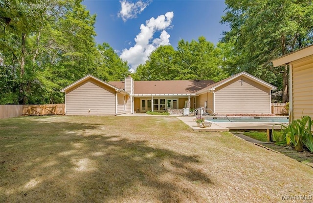 rear view of property featuring a patio and a yard