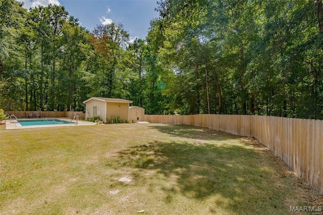 view of yard featuring a fenced in pool and a shed