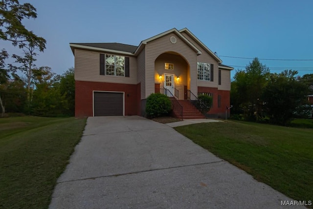 raised ranch featuring a yard and a garage