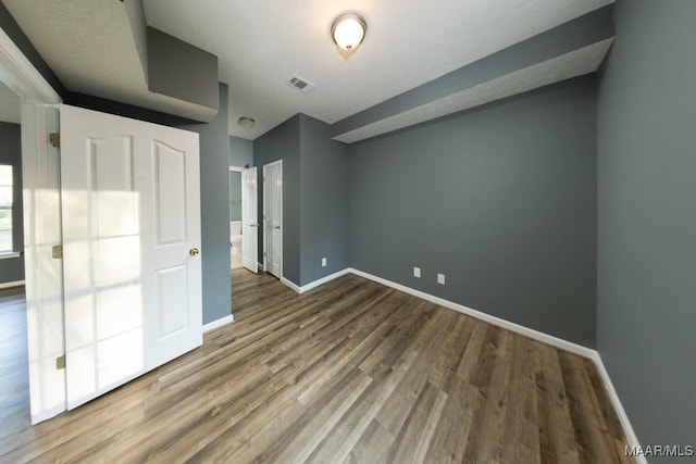 unfurnished bedroom with hardwood / wood-style flooring