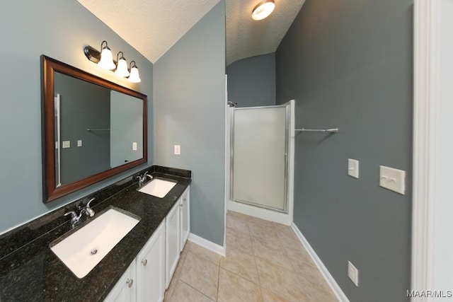 bathroom with a textured ceiling, lofted ceiling, tile patterned flooring, vanity, and a shower