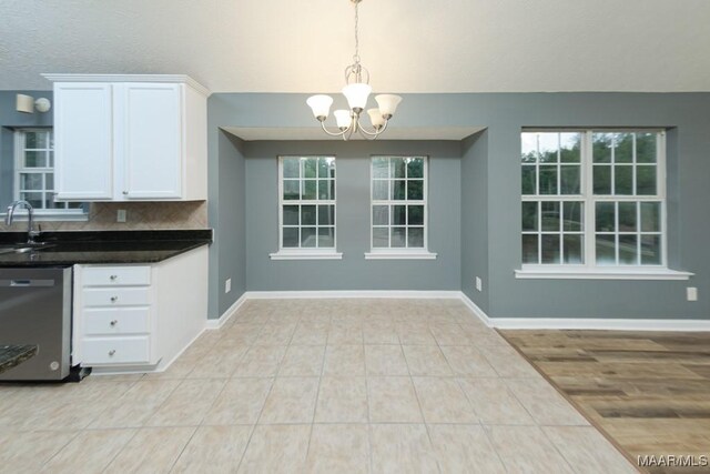 unfurnished dining area with sink, an inviting chandelier, and light tile patterned floors