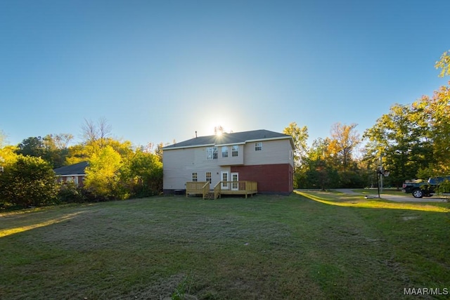 rear view of property featuring a deck and a lawn