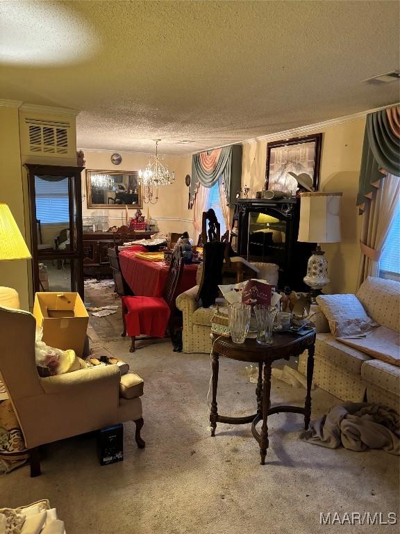 carpeted living room featuring a notable chandelier, crown molding, a fireplace, and a textured ceiling