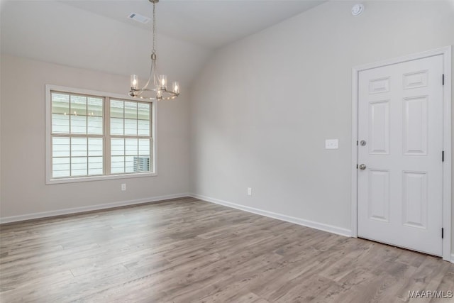 unfurnished room featuring lofted ceiling, light hardwood / wood-style flooring, and a notable chandelier