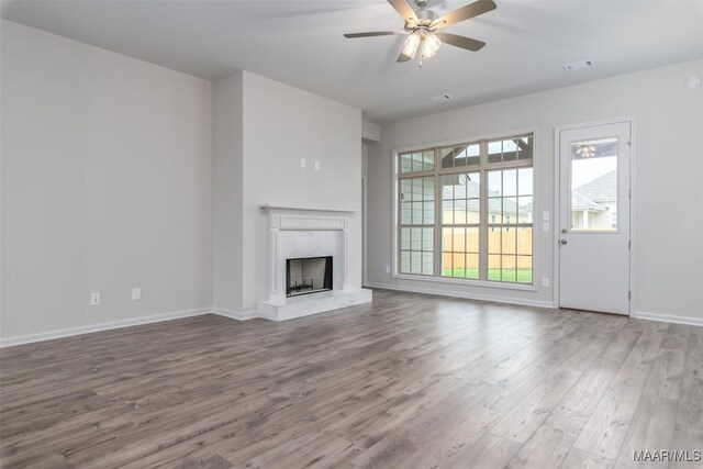 unfurnished living room featuring wood-type flooring and ceiling fan