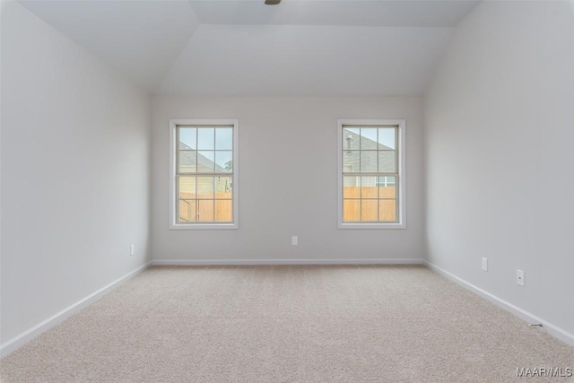 carpeted spare room with vaulted ceiling and a healthy amount of sunlight