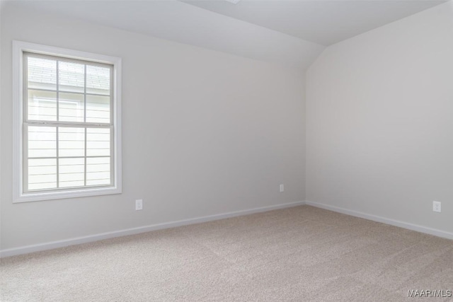 empty room with lofted ceiling and carpet