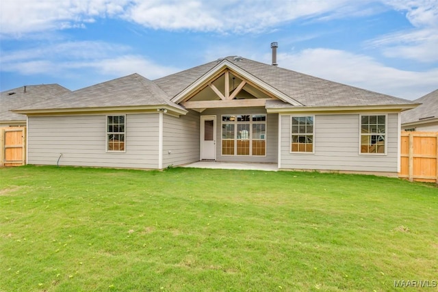 rear view of property with a yard and a patio area