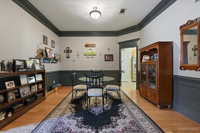 dining room featuring light hardwood / wood-style flooring and ornamental molding