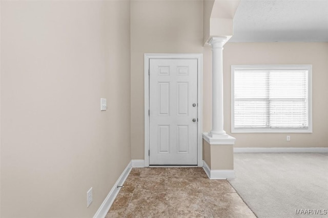 foyer entrance with light carpet and ornate columns