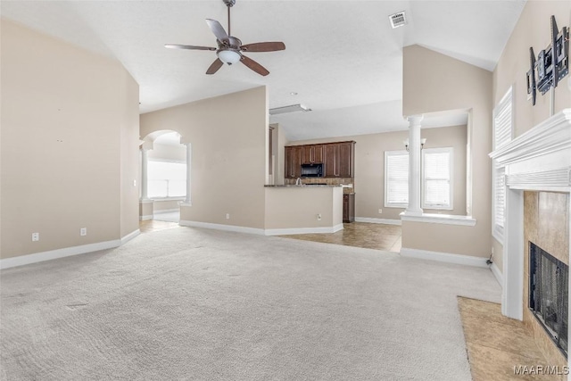 unfurnished living room featuring ceiling fan, light colored carpet, lofted ceiling, and a fireplace