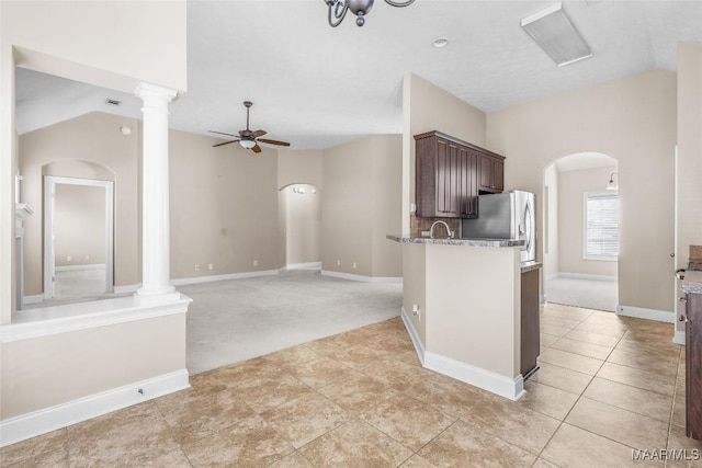 kitchen featuring stainless steel refrigerator with ice dispenser, dark brown cabinets, ornate columns, and ceiling fan