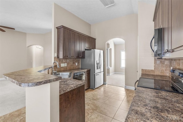 kitchen featuring black appliances, light tile patterned floors, sink, kitchen peninsula, and backsplash